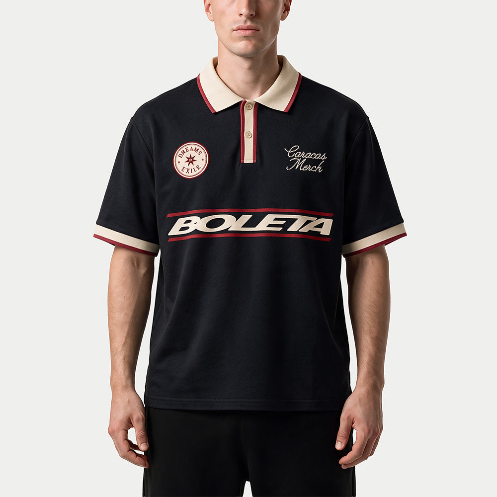Hombre llevando el polo de fútbol negro bicolor «Boleta» de Caracas Merch